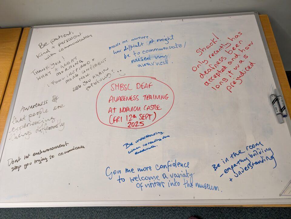 A whiteboard displays handwritten notes from a deaf awareness training session, centered around a red circle highlighting “SHSBC Deaf Awareness Training at Norman Castle (Fri 12th Sept) 2025.”.
